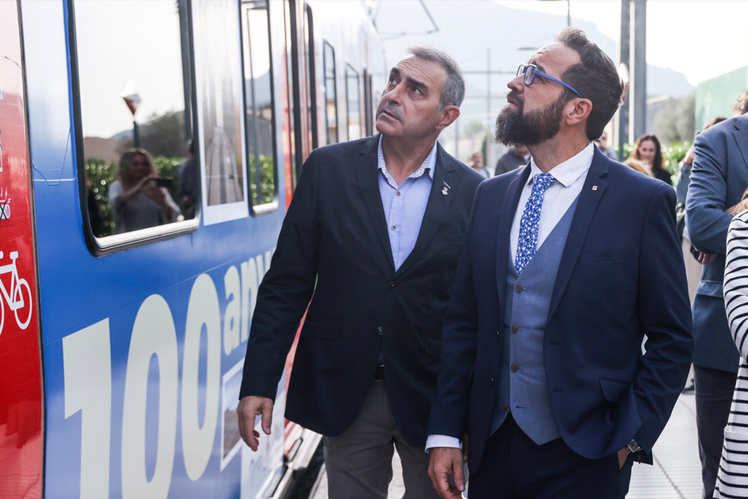 L’alcalde de Monistrol de Montserrat, Joan Miguel i Rodríguez, i el conseller Juli Fernàndez i Olivares, davant de tren vinilat > Departament de Territori