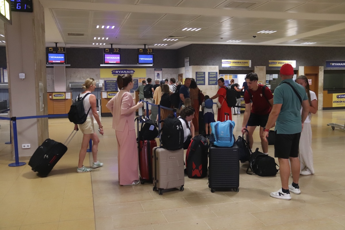 Un grup de passatgers espera per facturar l'equipatge al tauell de Ryanair a l'aeroport de Girona
