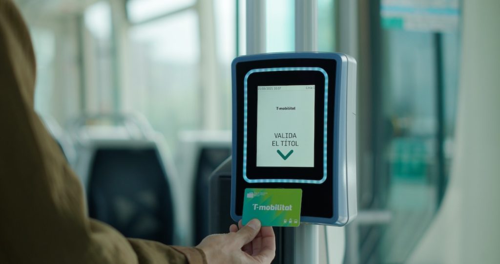 Una persona valida la T-mobilitat personalitzada al tramvia.