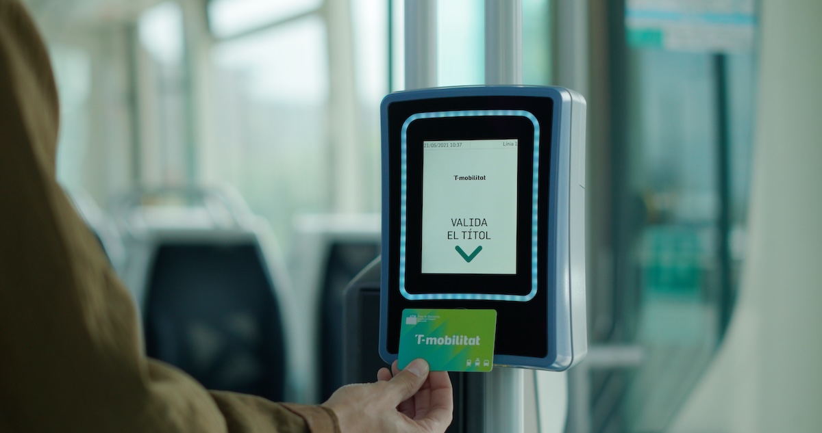 Una persona valida la T-mobilitat personalitzada al tramvia.